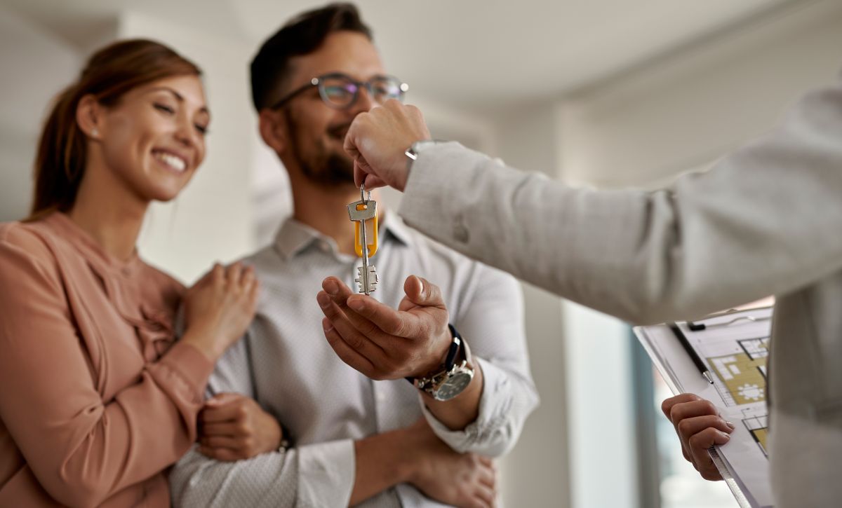 real-estate-agent-giving-couple-keys-their-new-home